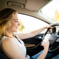 Girl viewing her phone while driving
