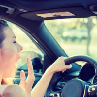 A woman yawning while driving