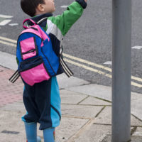 a little boy pushing crosswalk button