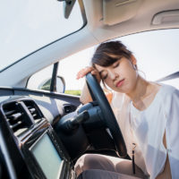 young female driver sleeping in vehicle