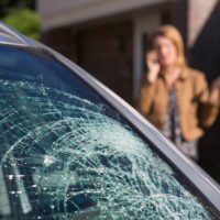 Woman calling For Help After finding broken car windshield