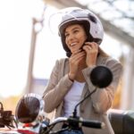 Woman on scooter tightens helmet